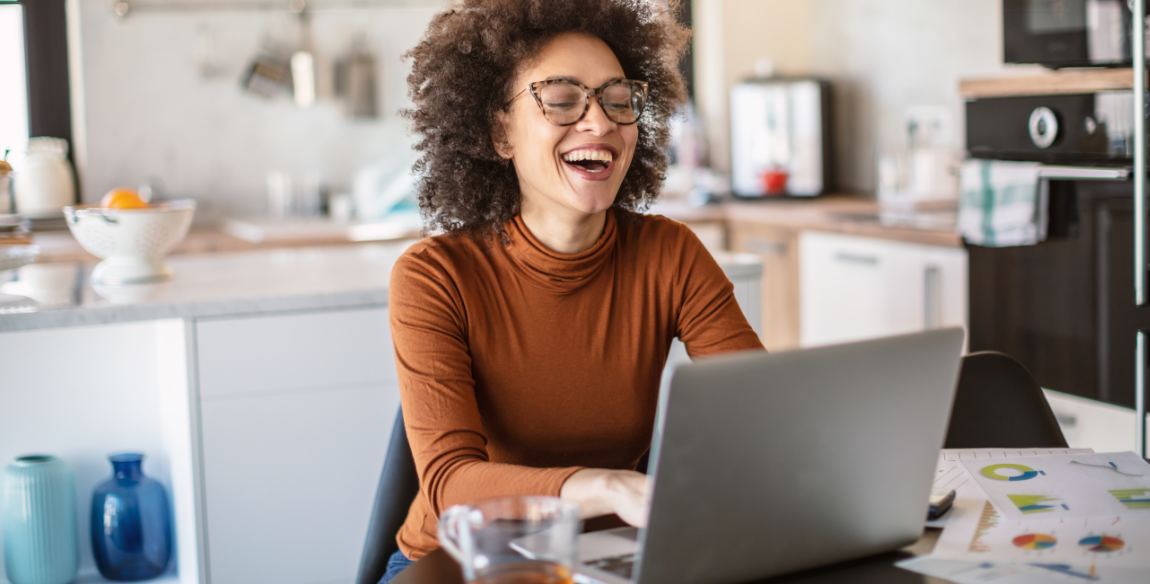 אישה מחייכת מול מחשב נייד