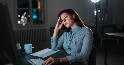 אישה עובדת מול מחשב בשעות נוספות